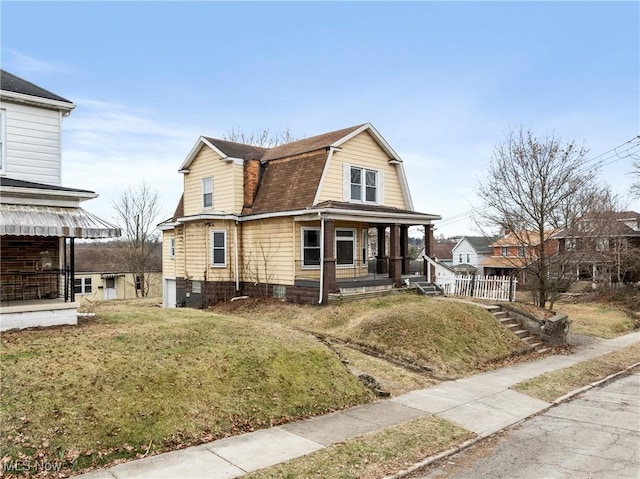 view of front of property featuring covered porch and a front lawn