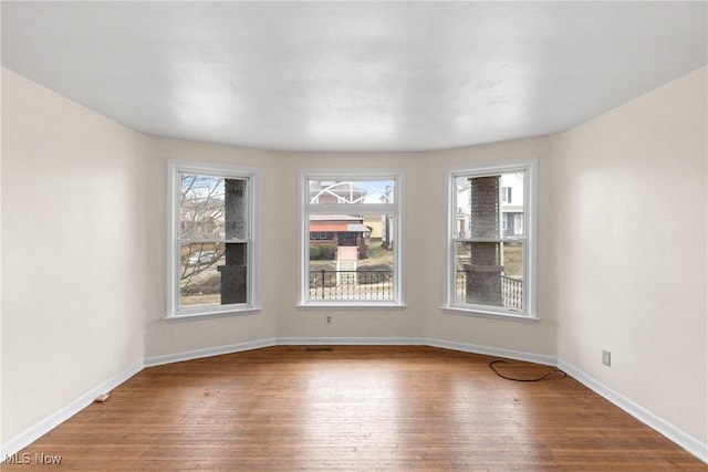 unfurnished room featuring hardwood / wood-style flooring and a wealth of natural light