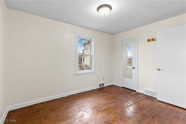 unfurnished room with dark wood-type flooring