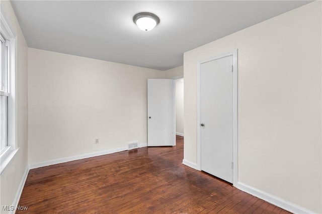 unfurnished room with dark hardwood / wood-style flooring