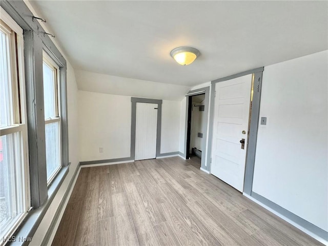 unfurnished room featuring vaulted ceiling and light hardwood / wood-style flooring