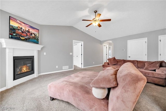 carpeted living room with ceiling fan and vaulted ceiling