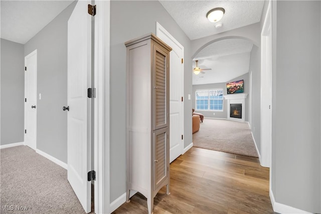 hall featuring a textured ceiling and carpet flooring