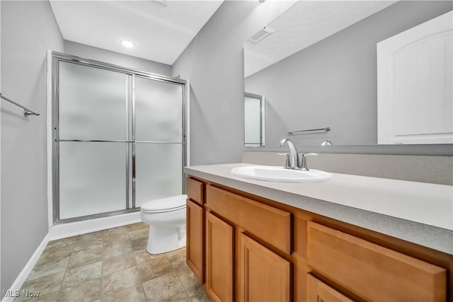 bathroom featuring vanity, toilet, and a shower with shower door