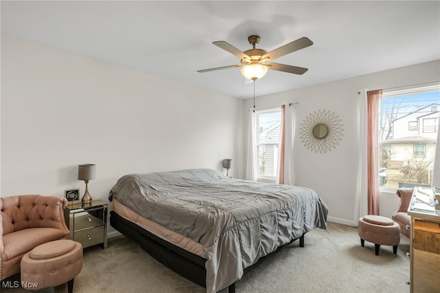 bedroom with light carpet, multiple windows, and ceiling fan