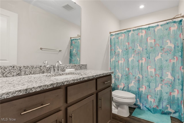 bathroom with vanity, hardwood / wood-style floors, a shower with shower curtain, and toilet