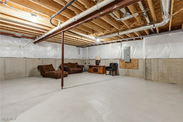 basement featuring electric panel and brick wall