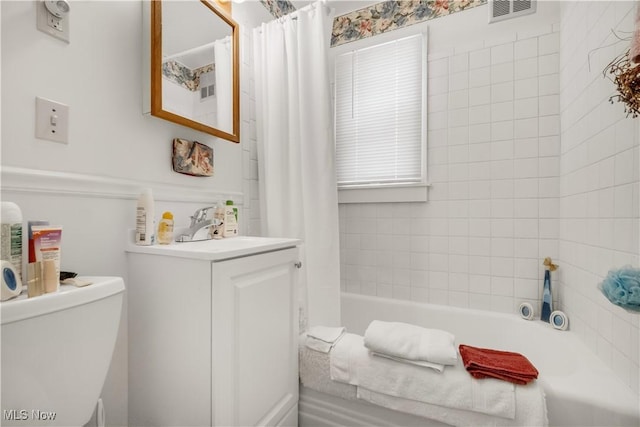 full bathroom featuring vanity, shower / bath combination with curtain, and toilet