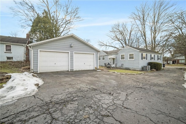 view of side of home with an outbuilding, a garage, and cooling unit