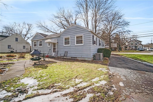 bungalow-style home featuring a patio, central AC, and a front lawn