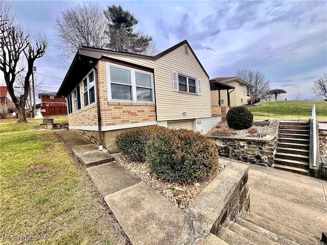 view of side of home with a garage and a lawn