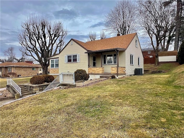 view of front of home featuring cooling unit and a front lawn