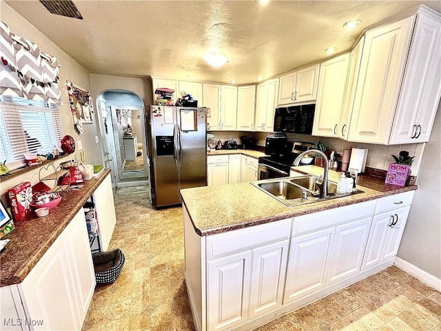 kitchen featuring white cabinetry, stainless steel fridge, and electric range oven