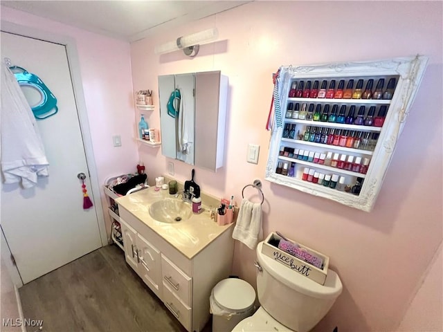 bathroom with hardwood / wood-style flooring, vanity, and toilet