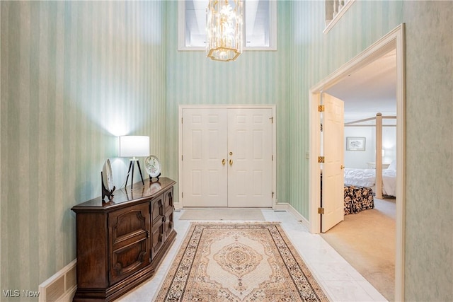 entrance foyer with light carpet and a notable chandelier