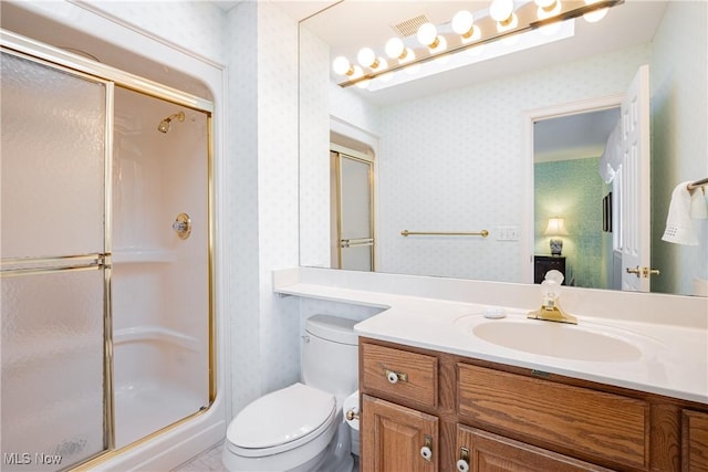 bathroom featuring vanity, toilet, and walk in shower