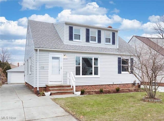 view of front of property with a garage, an outdoor structure, and a front yard