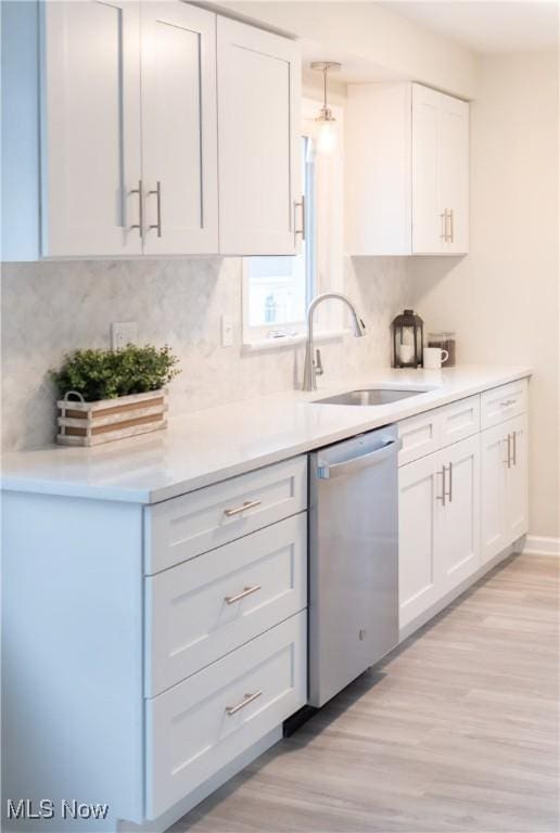 kitchen with pendant lighting, white cabinets, sink, and dishwasher