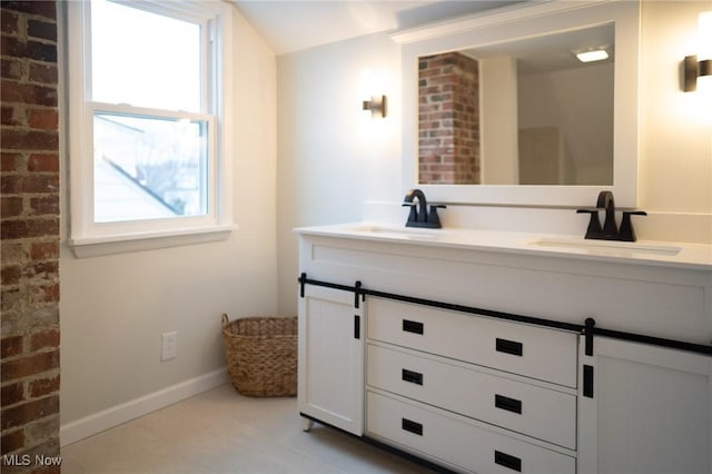 bathroom featuring brick wall and vanity