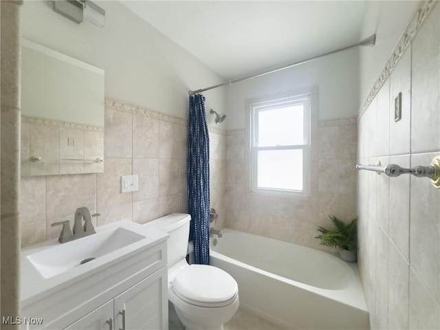 full bathroom featuring toilet, vanity, shower / bathtub combination with curtain, and tile walls