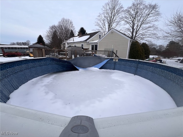 snow covered pool featuring a deck