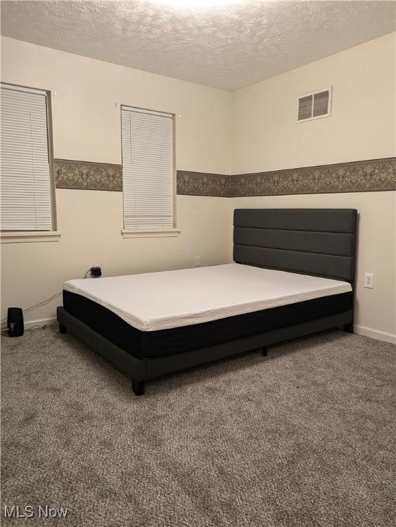 unfurnished bedroom featuring carpet floors and a textured ceiling