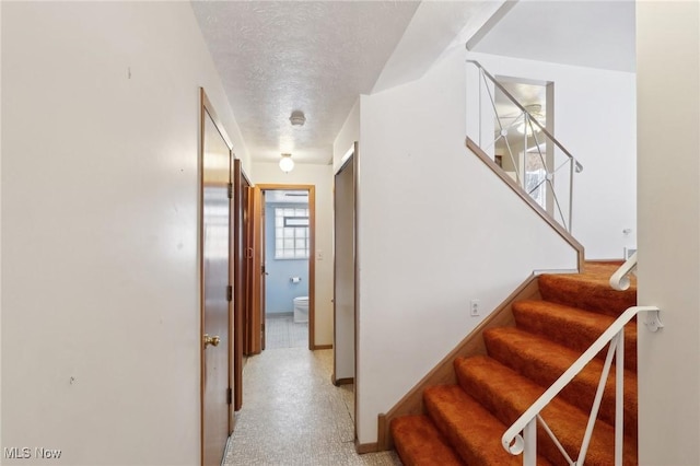 staircase with a textured ceiling