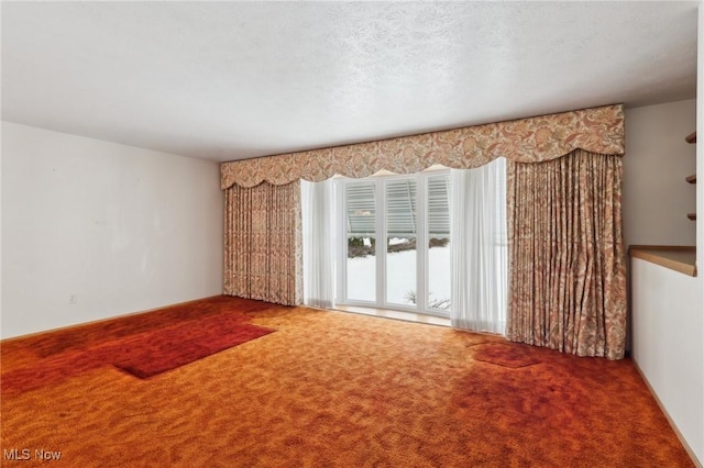 spare room featuring carpet flooring and a textured ceiling