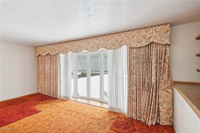 carpeted spare room featuring a textured ceiling