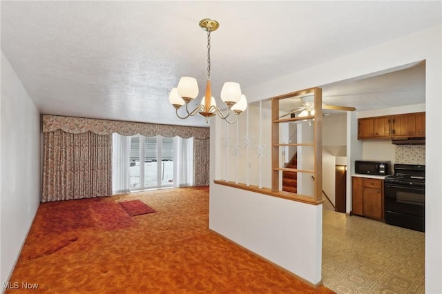 kitchen featuring pendant lighting, ceiling fan with notable chandelier, black appliances, and decorative backsplash