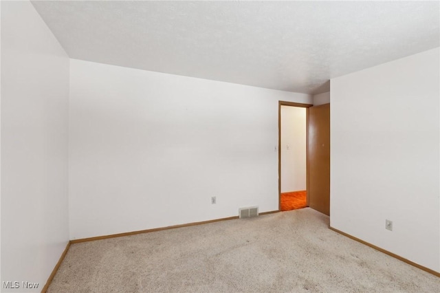 spare room featuring light colored carpet