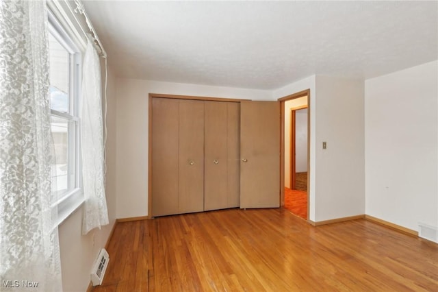 unfurnished bedroom featuring light hardwood / wood-style floors and a closet