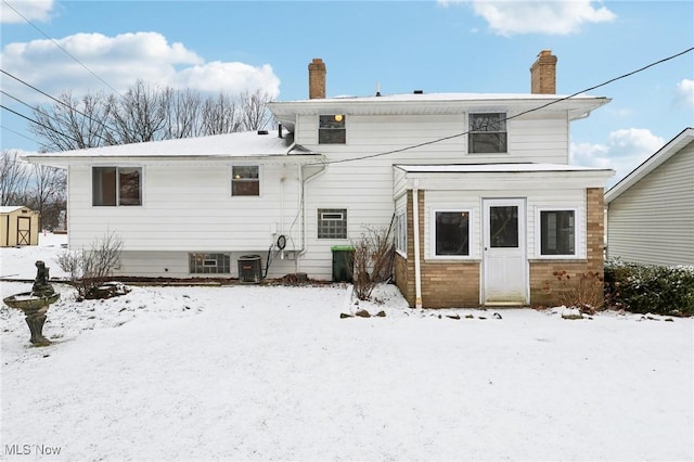 snow covered back of property with central air condition unit