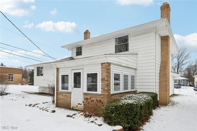 view of snow covered back of property