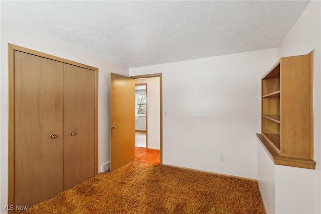 unfurnished bedroom with a closet, a textured ceiling, and carpet flooring