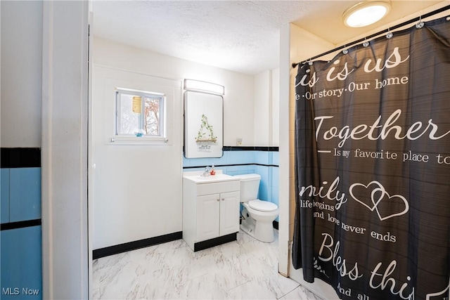 bathroom with tile walls, vanity, a textured ceiling, toilet, and walk in shower