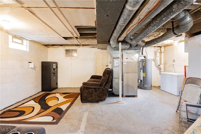 basement featuring heating unit, fridge, and water heater