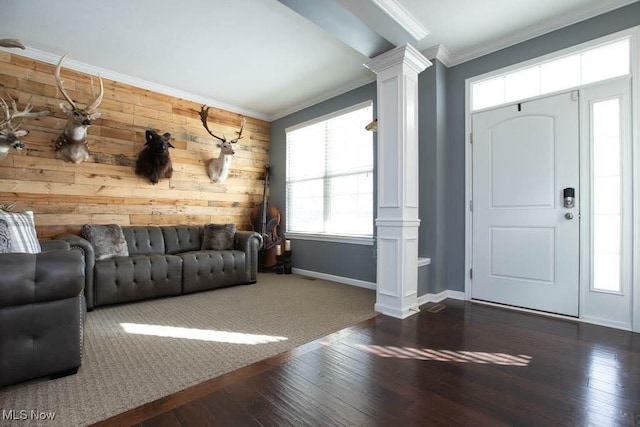 foyer featuring crown molding, wood walls, dark hardwood / wood-style flooring, and ornate columns