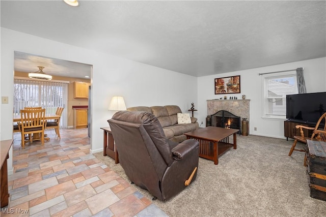 living room featuring plenty of natural light, light carpet, and a high end fireplace