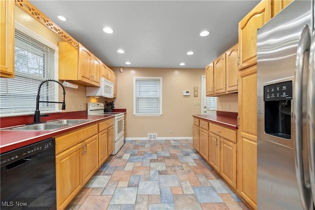 kitchen with sink, white appliances, and light brown cabinets