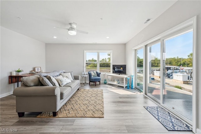 living room with light hardwood / wood-style floors and ceiling fan