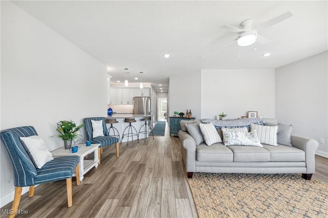 living room with wood-type flooring and ceiling fan