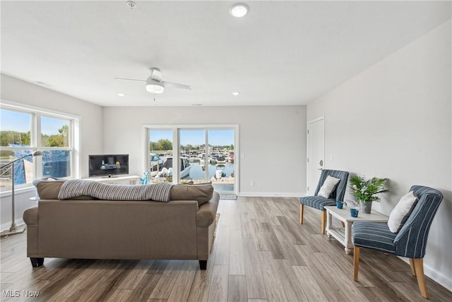 living room with ceiling fan and light wood-type flooring