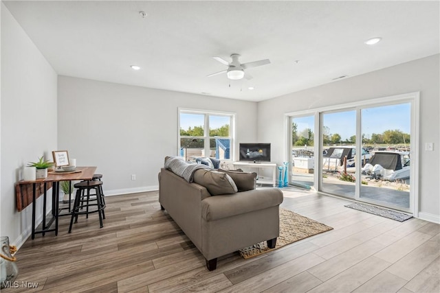 living room featuring ceiling fan and light wood-type flooring