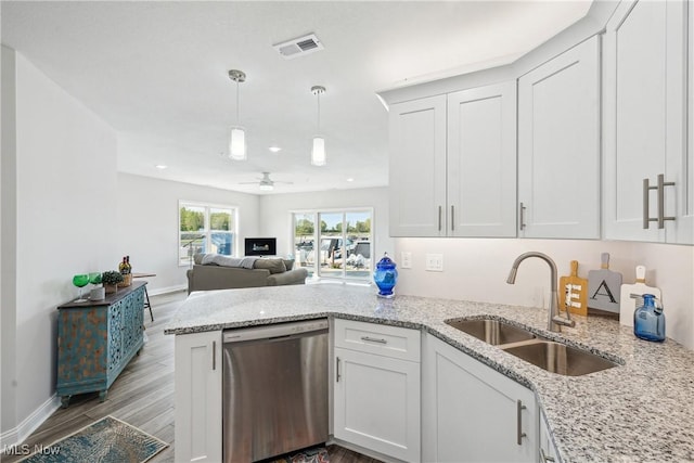 kitchen with white cabinetry, sink, hanging light fixtures, stainless steel dishwasher, and light stone countertops