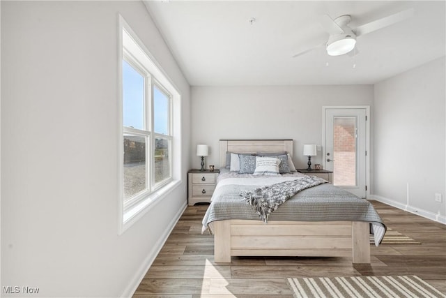 bedroom featuring hardwood / wood-style flooring, access to outside, and ceiling fan