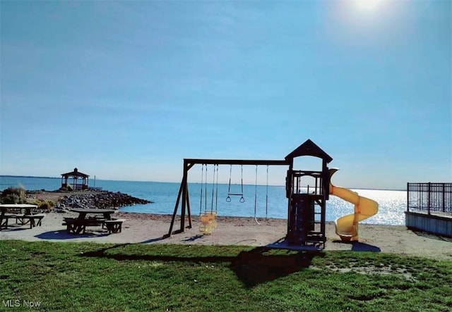 view of jungle gym with a water view and a lawn