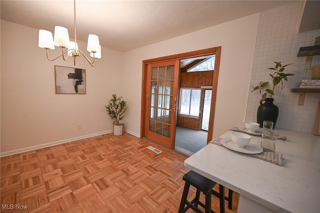 dining room with a chandelier and light parquet floors