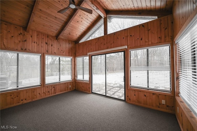 unfurnished sunroom featuring ceiling fan, a healthy amount of sunlight, wooden ceiling, and vaulted ceiling with beams