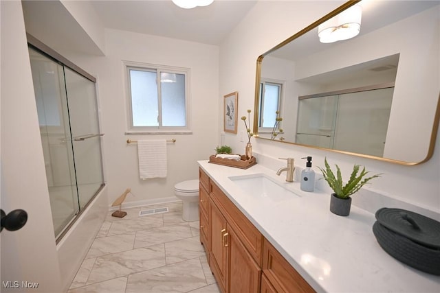 full bathroom featuring toilet, vanity, and shower / bath combination with glass door